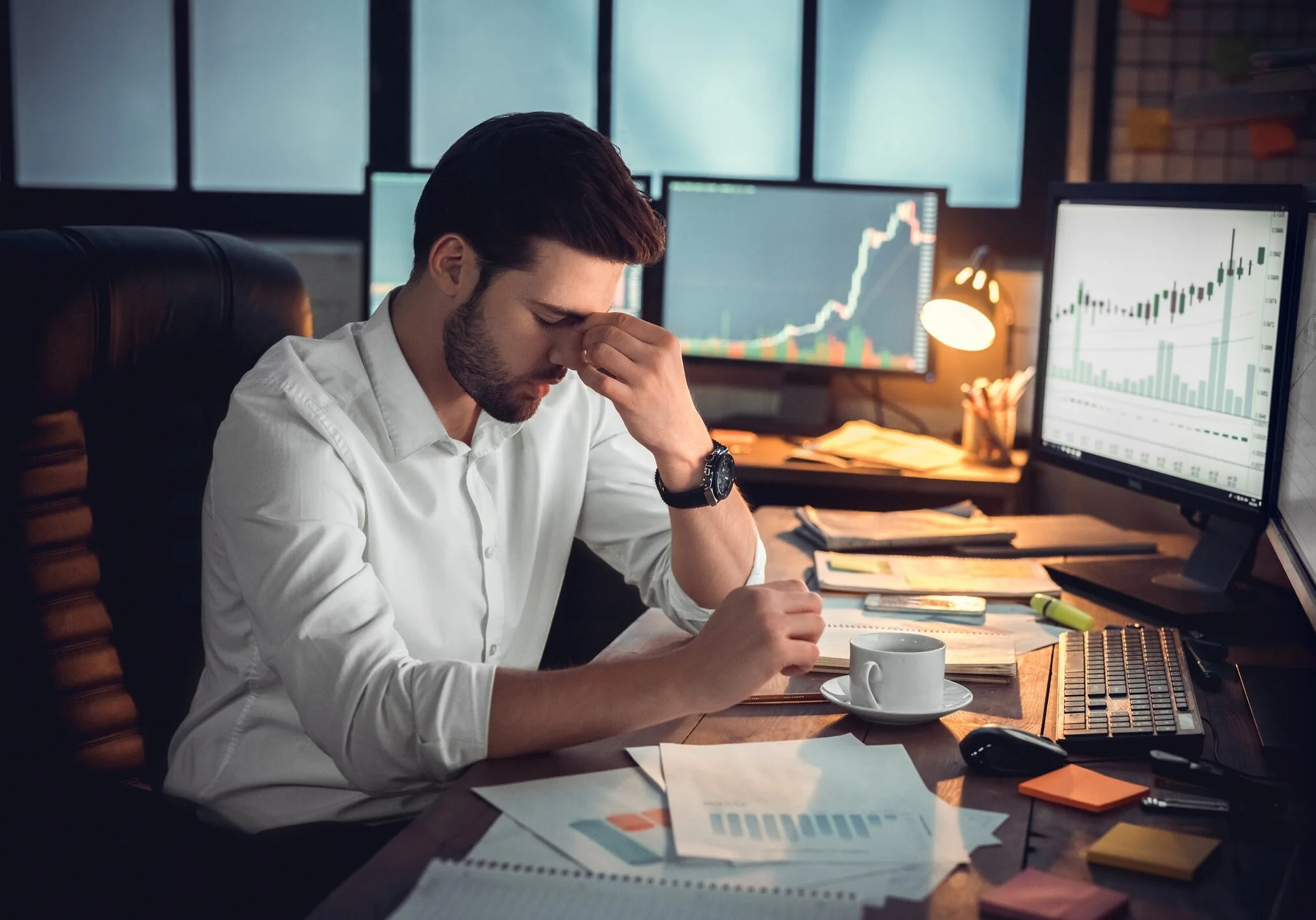 Depressed frustrated trader tired of overwork or stressed by bankruptcy, sad shocked investor desperate about financial crisis or money loss, upset businessman having headache massaging nose bridge